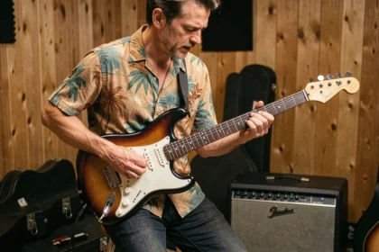 Guitariste jouant du surf rock sur une Stratocaster sunburst avec micros Samarium Cobalt Noiseless dans un studio de répétition vintage